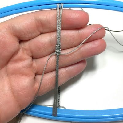 a hand holding an electric wire in front of a blue cable with two wires attached to it