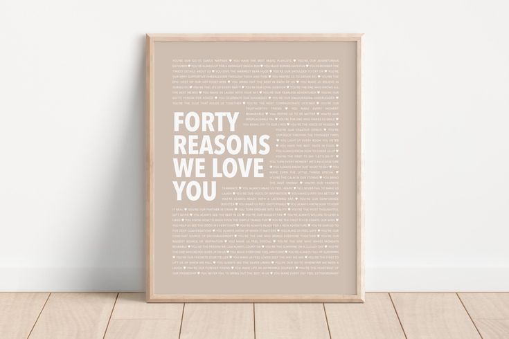 a framed poster with the words forty reasons we love you in white on a wooden floor