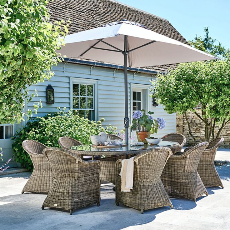 an outdoor table with chairs and an umbrella