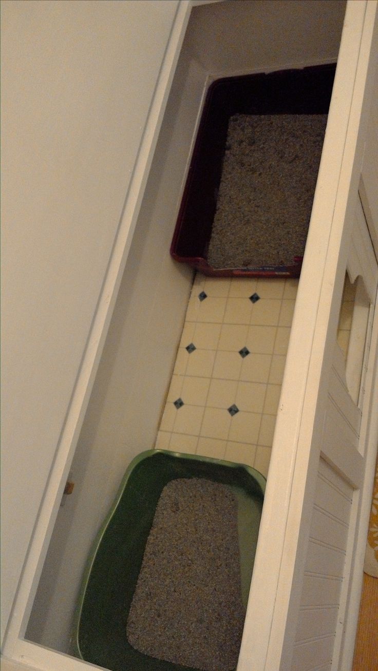 two cats litter boxes sitting in the corner of a room with white walls and tile flooring