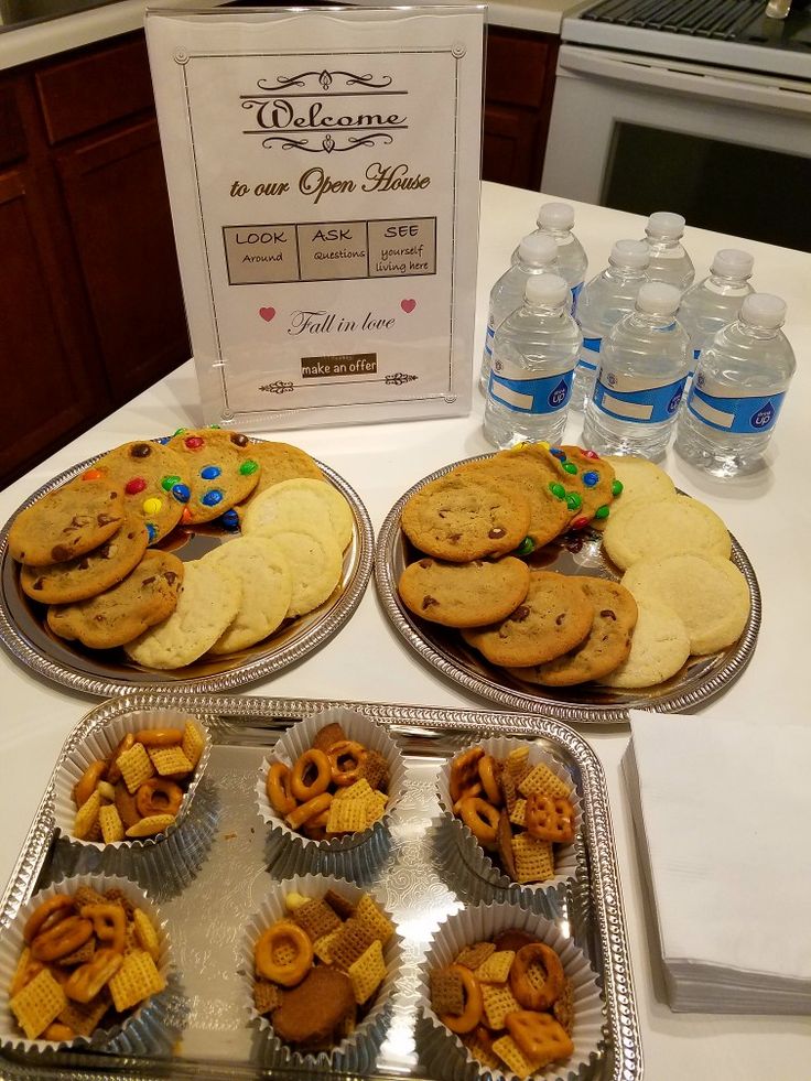 two trays filled with cookies and crackers on top of a table next to water bottles