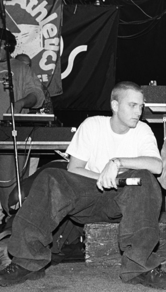 black and white photograph of two men sitting on stools in front of microphones