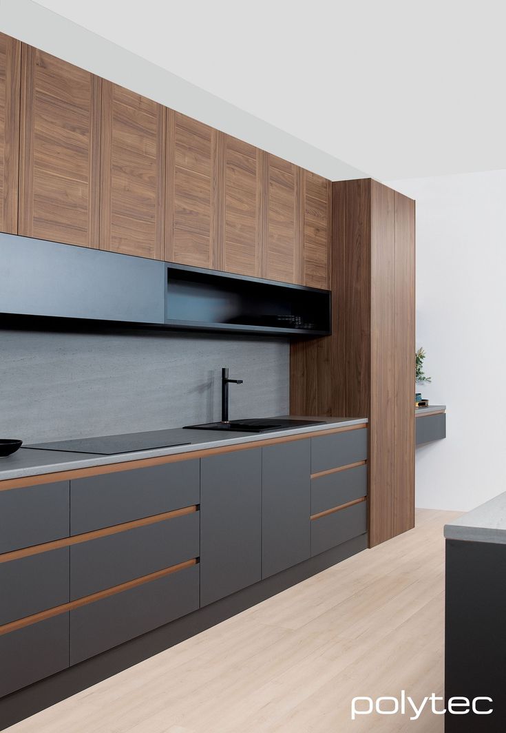 a modern kitchen with wooden cabinets and black counter tops, along with an island in the middle