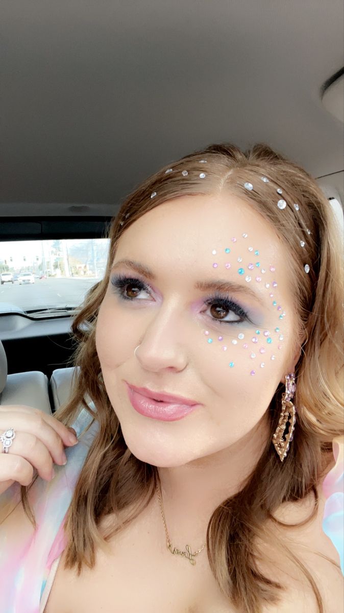 a woman with glitter on her face sitting in a car