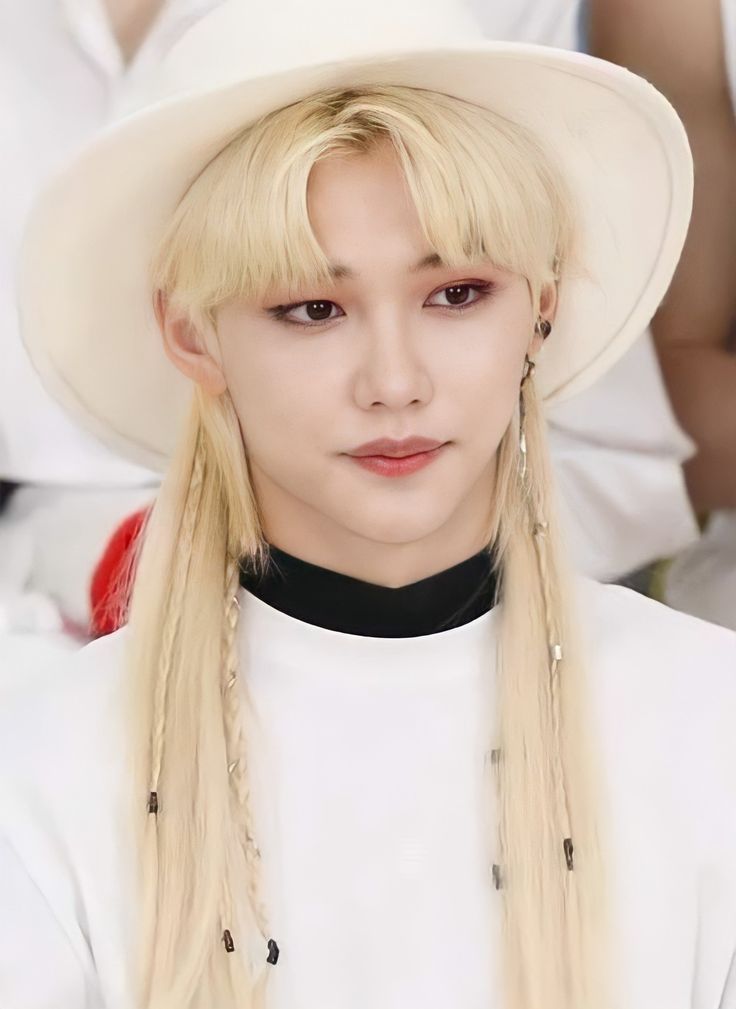 a woman with long blonde hair wearing a white hat