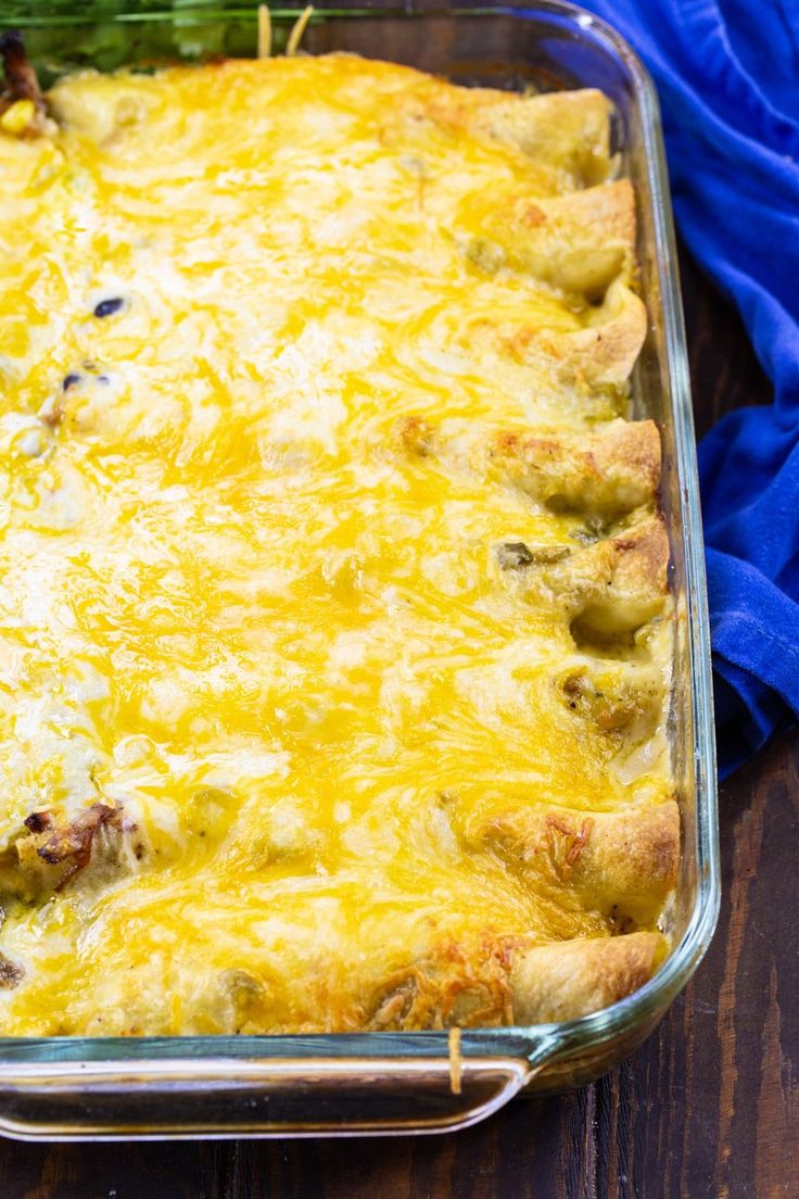 a casserole dish with meat and cheese in it sitting on a wooden table