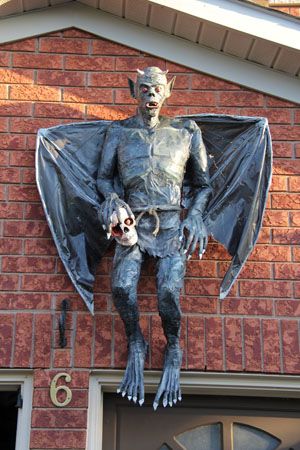 there is a statue of a man with a bat on the side of a building