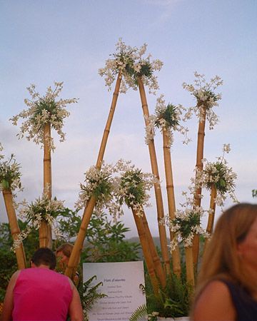 two people are sitting at a table with food and drinks in front of palm trees