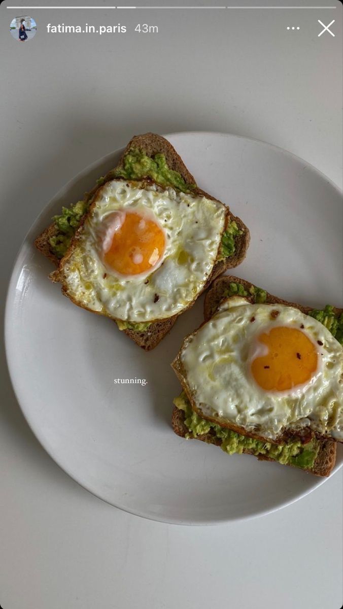 two pieces of toast with an egg on top and avocado in the middle