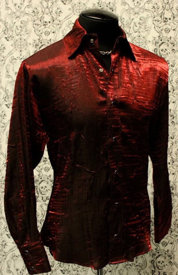 "A classic cut men's shirt with flash! Comfortable, light-weight dark red shimmer fabric adds a lot of style to a traditional cut. A generous, slimming fit fastened with rich black pearl snaps down front and at cuffs. Definitely will make you stand out in a crowd. Comes in sizes small-XXL. These shirts are large and drapey. Order a size smaller than what you usually wear. Check the measurements below. Measurements: Small: Chest 46\" Waist 42\" Medium: Chest 49\" Waist 44\" Large: Chest 52\" Wais