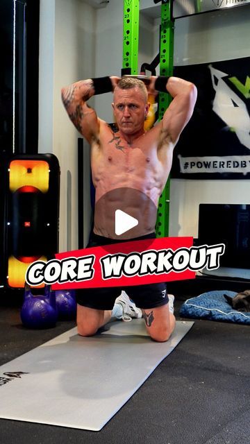 a man with no shirt is doing exercises on the floor in front of his gym equipment