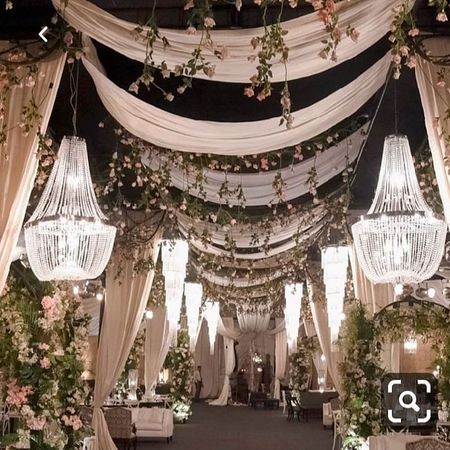 an outdoor wedding venue with chandeliers and flowers