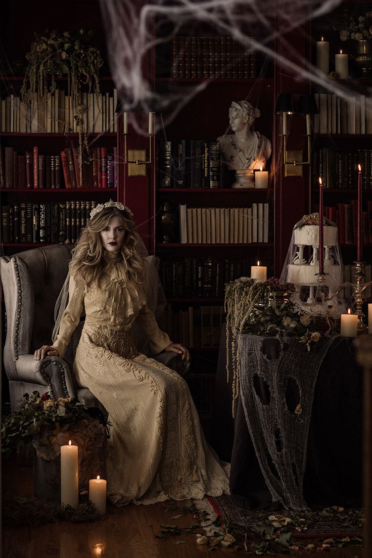 a woman sitting on a chair in front of a bookshelf filled with candles