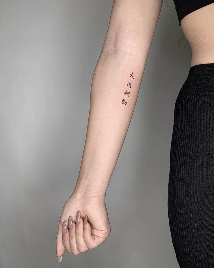 a woman's arm with chinese characters tattooed on the left side of her arm