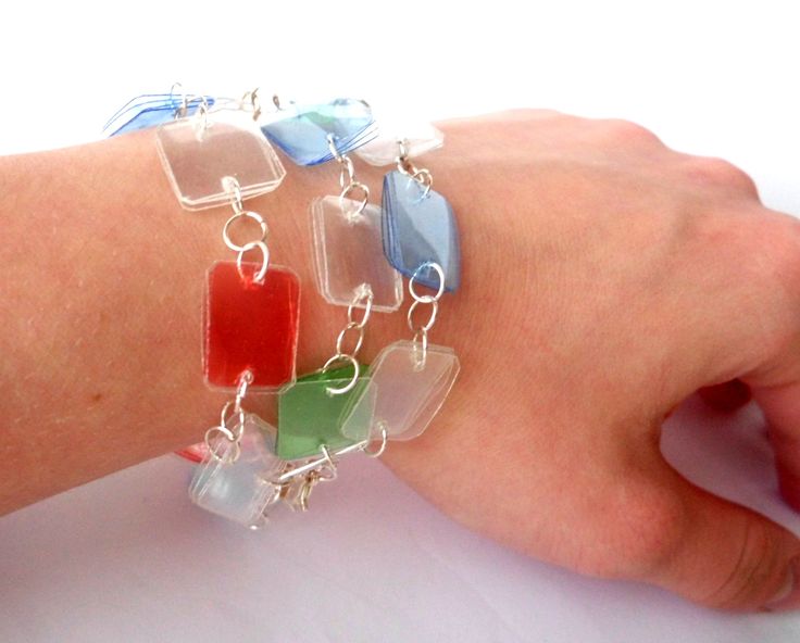 a person's arm with a bracelet made out of different colored pieces of glass