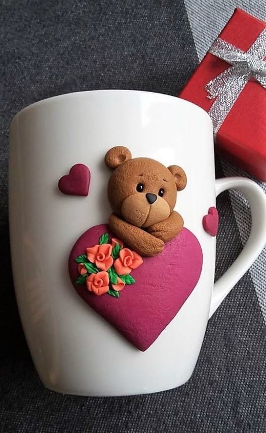 a teddy bear sitting on top of a heart shaped coffee cup