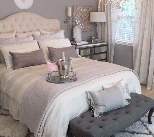 a bedroom with a large bed and chandelier