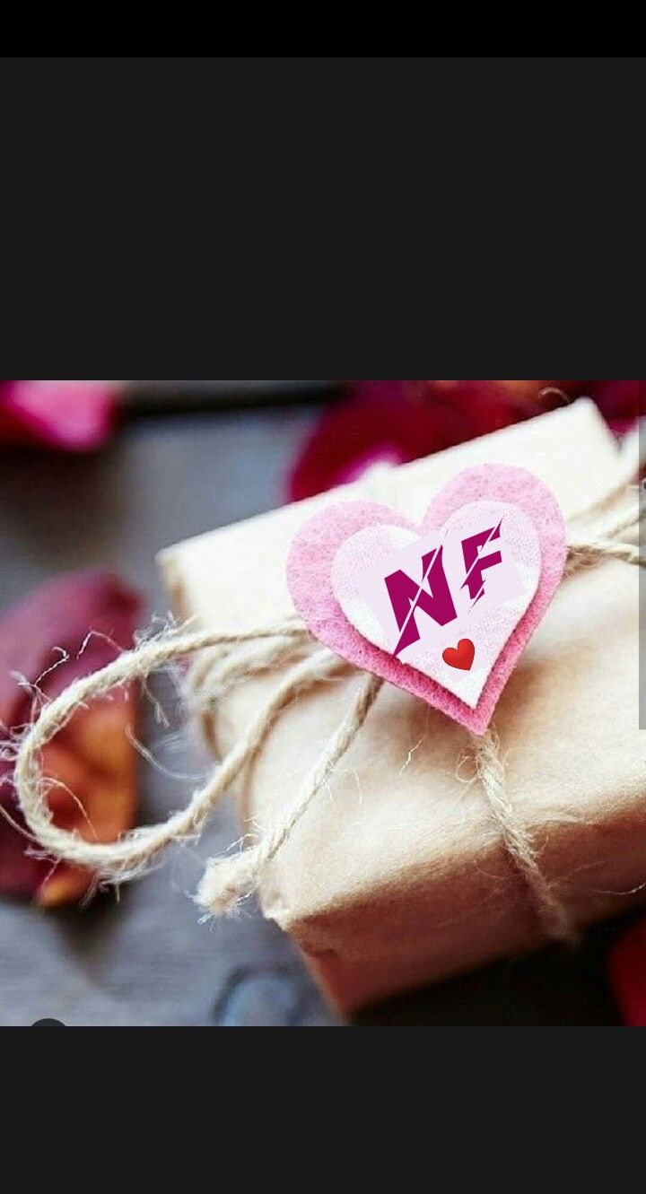 a gift wrapped in brown paper with a pink heart on it and some twine