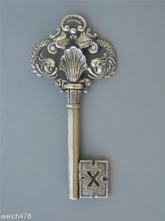 an ornate silver key is attached to a wall