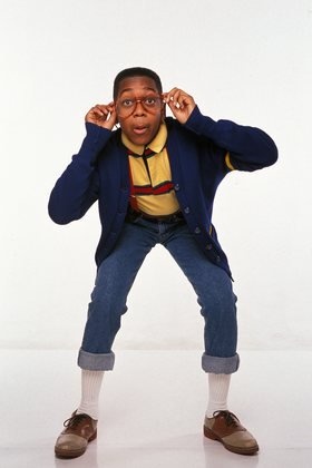 a man with glasses is posing for the camera while wearing a blue jacket and tie