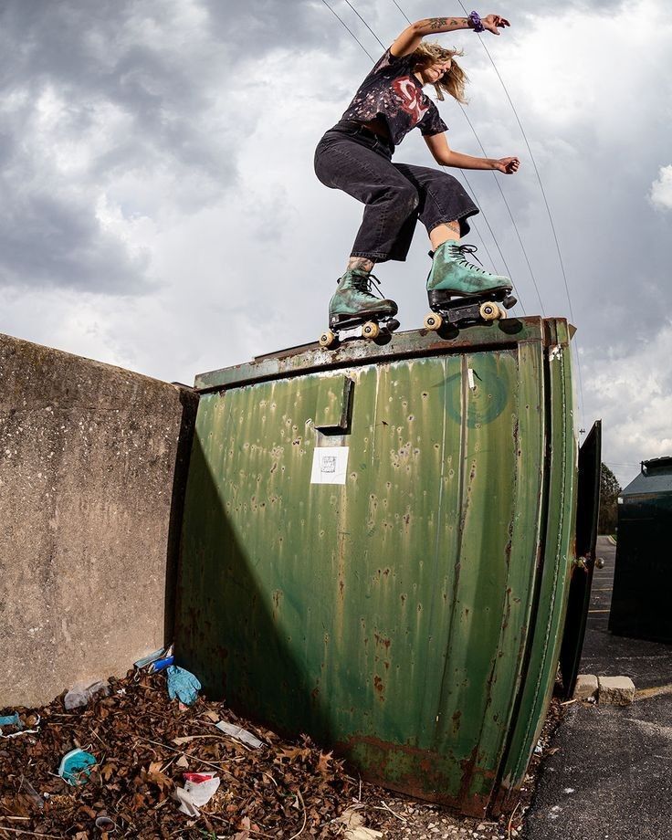 a person riding a skateboard on top of a trash can