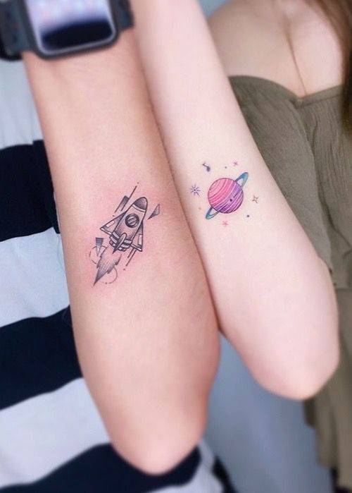 two girls with matching tattoos on their arms