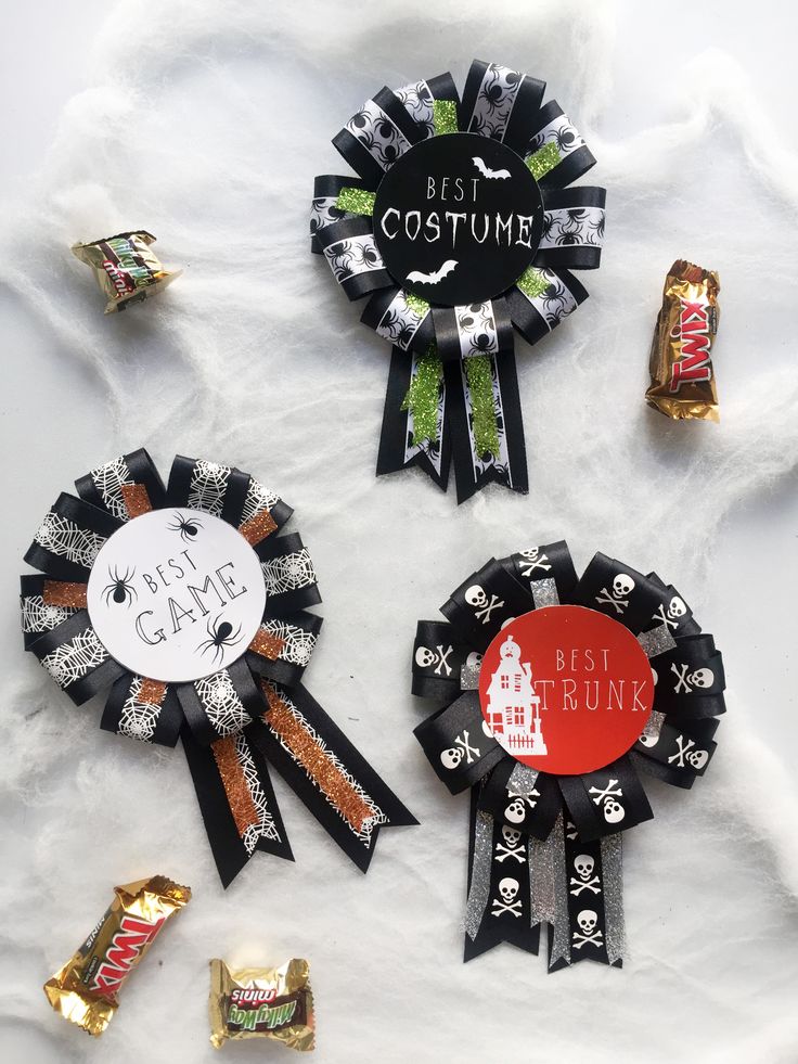 three ribbons with different designs on them and some candy bar wrappers in the background