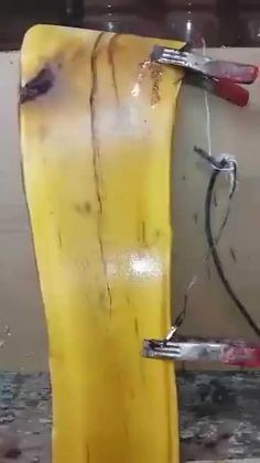 a yellow surfboard is being worked on with some tools attached to the back end