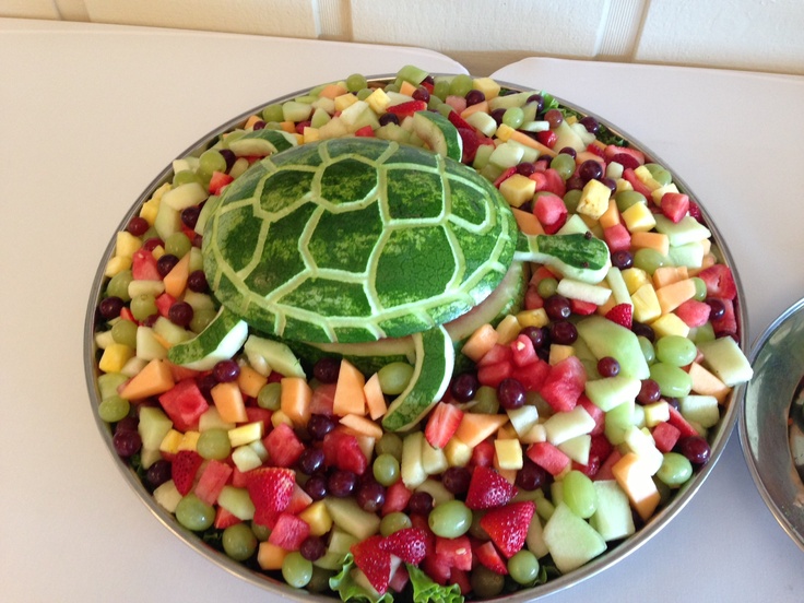 a bowl filled with fruit and a turtle shaped watermelon