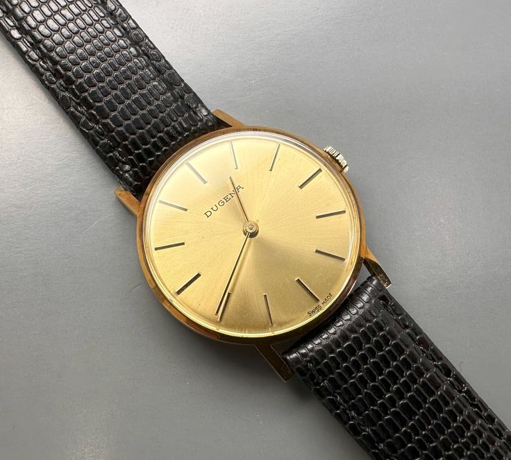 A fairly rare men's (unisex) 14k solid gold Swiss DUGENA watch with the classic Bauhaus look, with a gold punch on caseback, manual winding watch with a gold color dial, gorgeous, completely original, with lizard calf leather strap. The reverse is engraved, the watch is in good working condition, almost unworn pristine condition considering age, no scratches on the glass and case. Dates: 1979 Case size: 34 mm Total weight: approx. 29g A true classic, worth collecting! PLEASE NOTE: ALL MY WATCHES Antique Yellow Gold Watches For Business, Business Watches In Yellow Gold With Gold Clasp, Antique Gold Watch For Business, Gold Engraved Business Watches, Engraved Gold Business Watches, Gold Punch, Wrist Watches, Slovenia, Danish Design