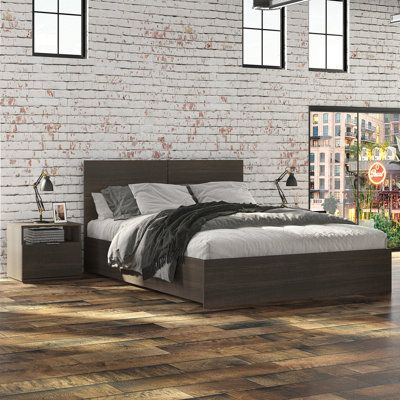 a bedroom with brick walls and hardwood floors