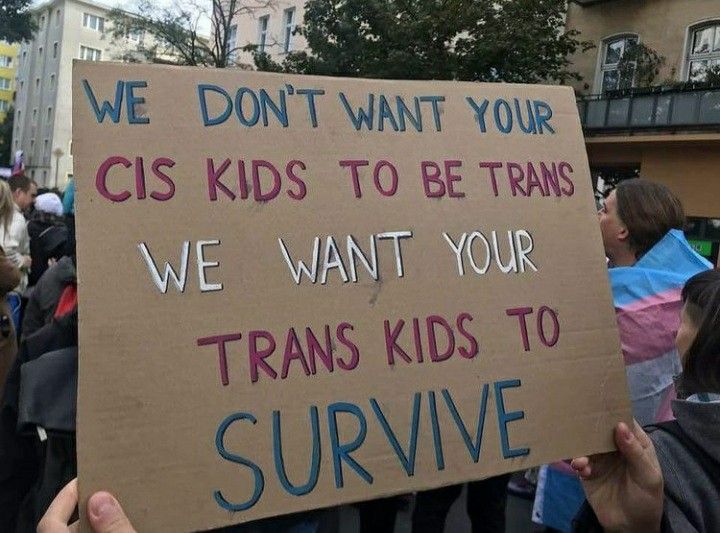 a group of people holding up signs in the middle of a street with words written on them