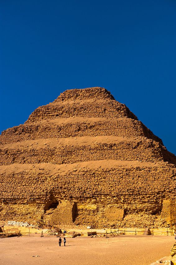 two people are standing in front of the pyramid