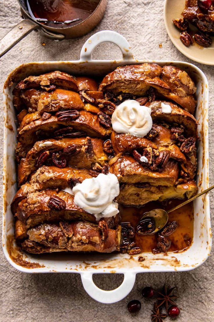 a casserole dish with pecans and whipped cream