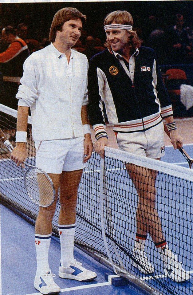 two tennis players standing next to each other holding racquets on a court