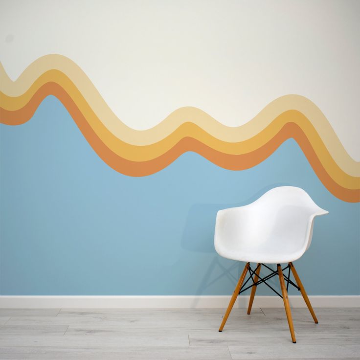 a white chair sitting in front of a wall with an abstract painting on it's side