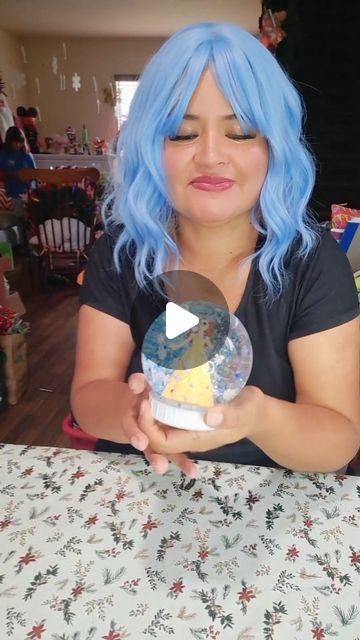 a woman with blue hair is holding an object