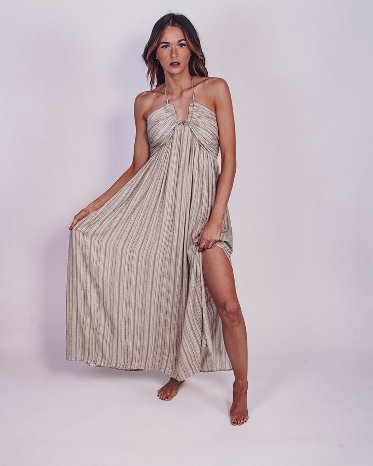 Vacay approved is our From The Source Pocketed Halter Maxi Dress is perfect for any event this season. We love the flowy, lightweight striped fabrication for a classy and flattering fit. Designed with maxi length on a plunging halter neckline, side pockets, partial elastic waistband and an adjustable back tie design. We are swooning over this adorable maxi and you will too! Pair with your favorite heels for a chic look or with sandals to keep it casual! Color: Black/Cream Maxi Length Bump Friend Bohemian Striped V-neck Maxi Dress, Elegant Striped Beach Dresses, Striped V-neck Maxi Dress For Spring, Striped Maxi Dress For The Beach, Striped Maxi Dress With Vertical Stripes For The Beach, Chic Striped Maxi Dress, Striped V-neck Maxi Dress For Vacation, Striped Lined Maxi Dress For The Beach, Chic Maxi Dress With Vertical Stripes For Vacation