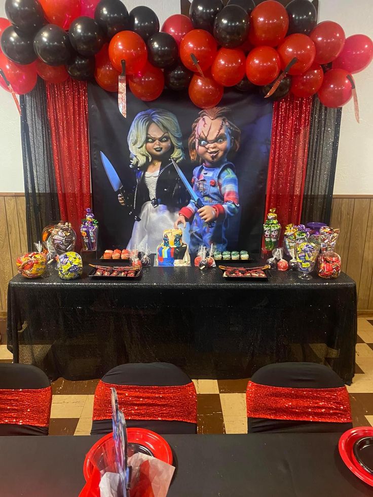 the table is set up with balloons, candy and decorations for this halloween themed party