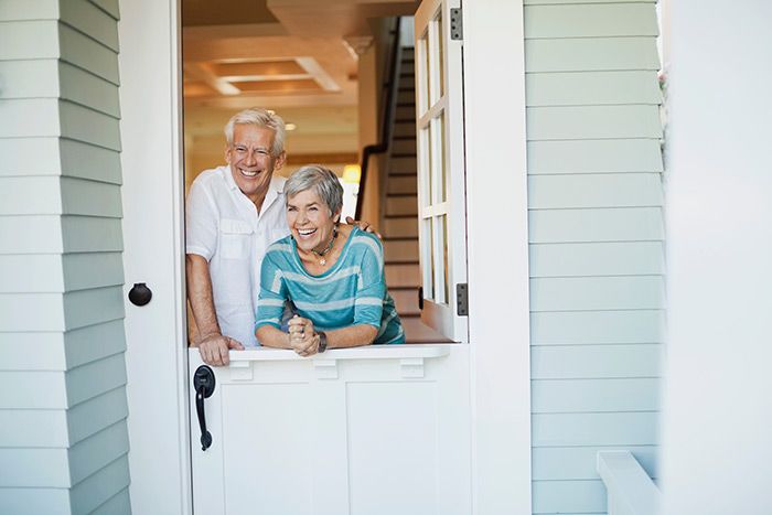 an older couple standing in the doorway of their home