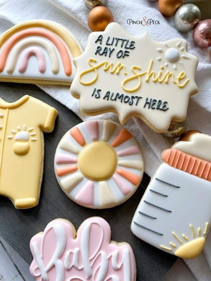 some cookies that are sitting on a table with decorations around them and the words baby written in white