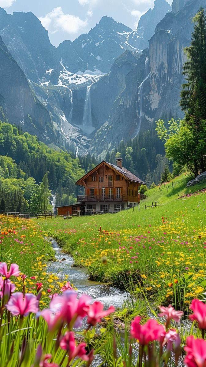 a house in the mountains surrounded by flowers