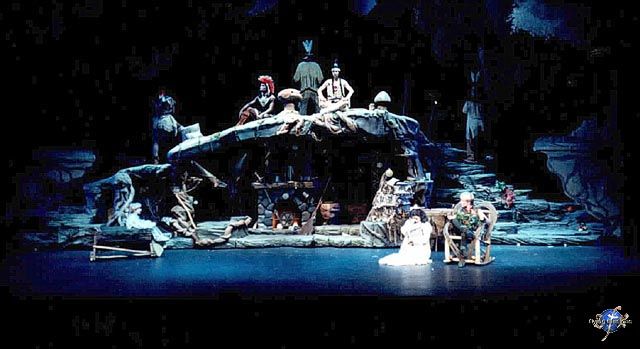 an image of a stage scene with people on the stage and one man in costume