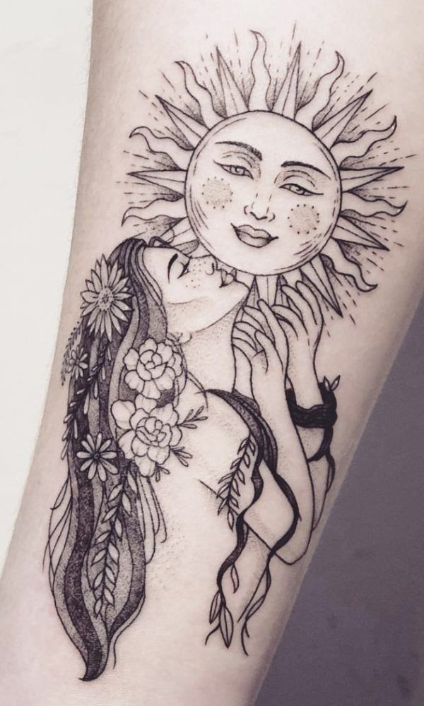 a woman's arm with a sun and flowers tattoo design on the left forearm