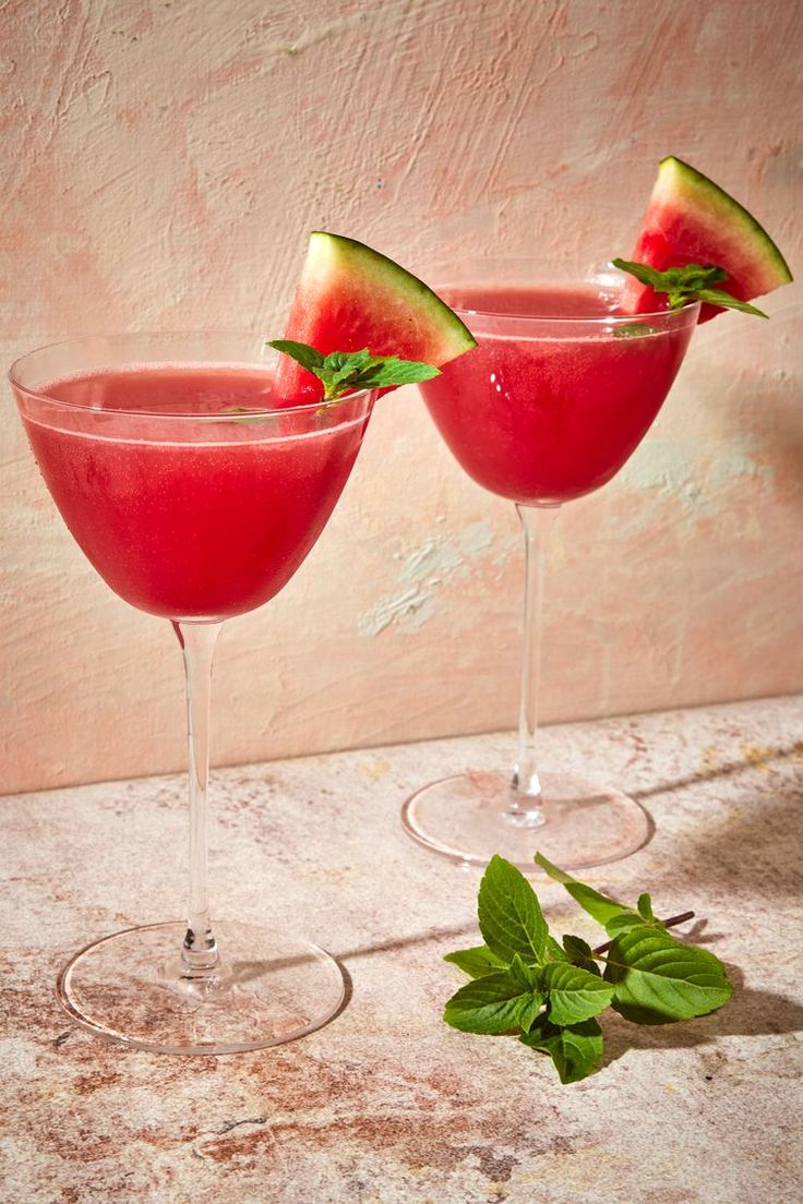 two wine glasses with watermelon and mint garnish