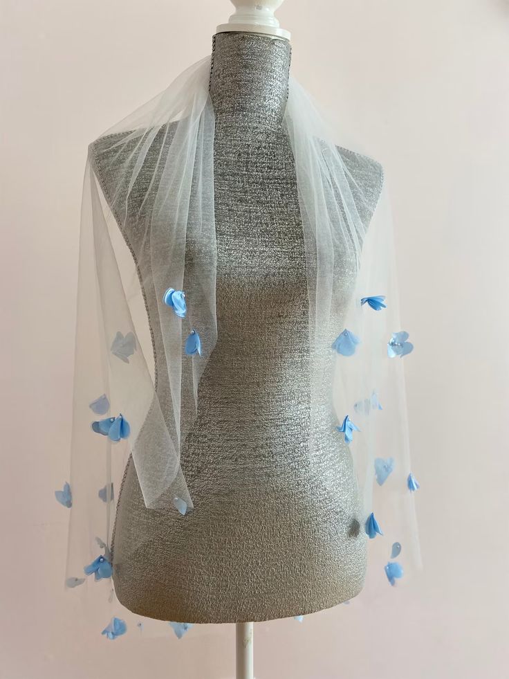 a mannequin wearing a veil with blue flowers on it