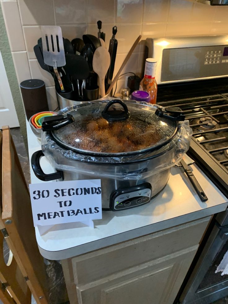 a large pot sitting on top of a stove next to a sign that says 30 seconds to meatballs