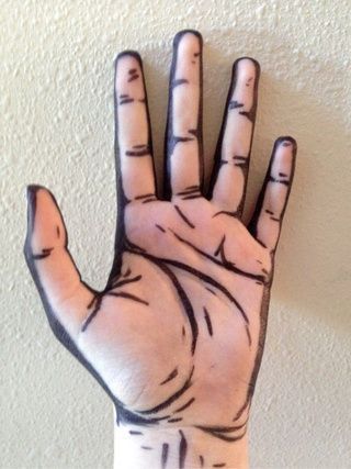 a person's hand painted with black and white lines on it, in front of a wall