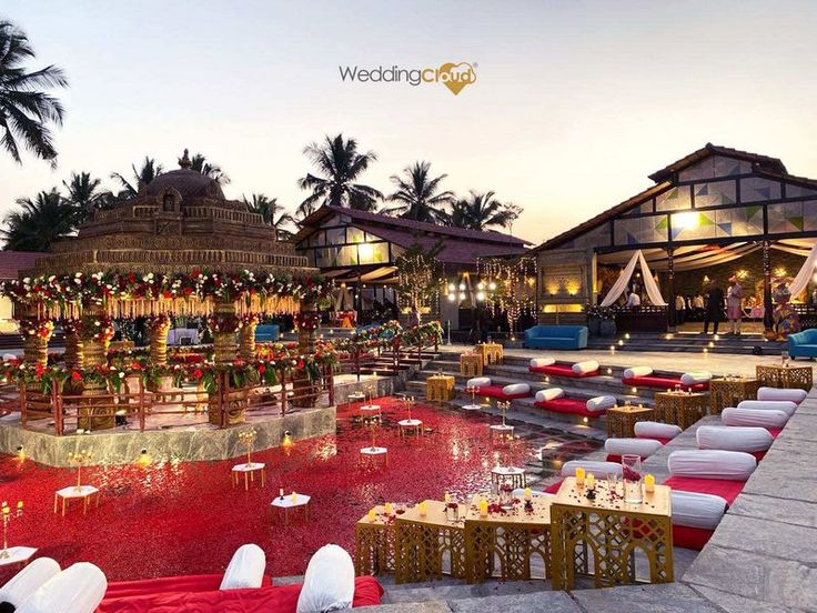 an outdoor event with tables and chairs set up in front of the pool at night