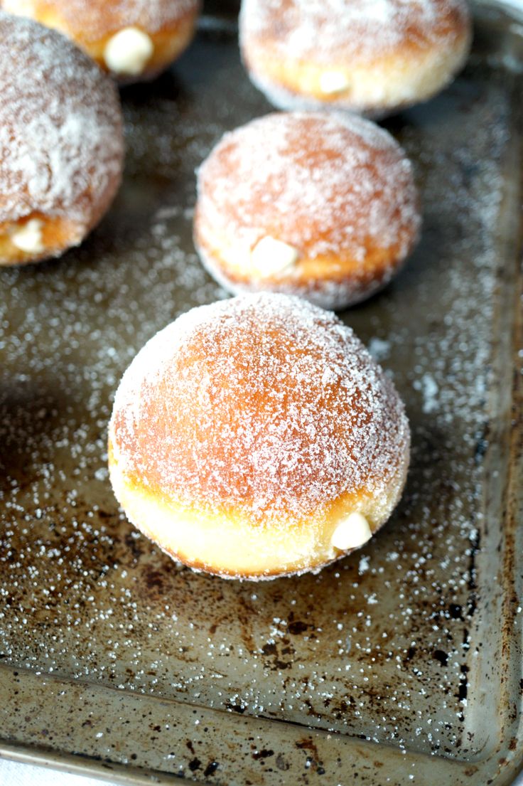 powdered sugar covered donuts on a baking sheet